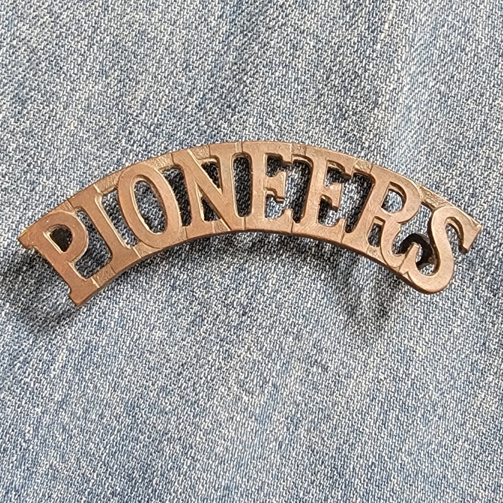 Antique pioneer tag/pin. 1/2 X 2 1/5 inches. Attaches with loops on either end.